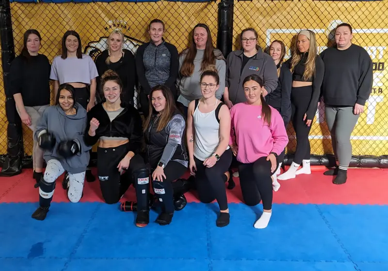 A group of women on the mats at a Women of Combat session